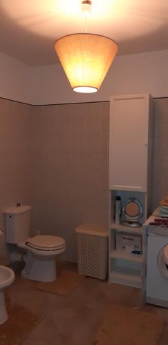 a bathroom with a toilet and a light on the ceiling at Villa rux platamona in Sassari