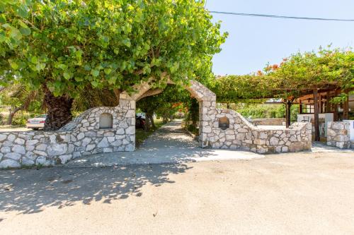 a stone building with a tree and a stone wall at Ohana in Kamisianá