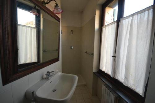 a bathroom with a sink and a mirror and two windows at Holiday Home Chiavari in Chiavari