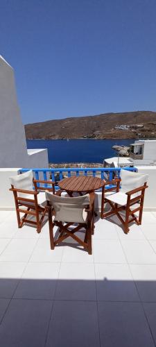 a wooden table and two chairs and a table and bench at Hotel Agnadi in Amorgos