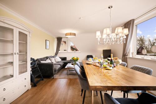 a dining room and living room with a wooden table at Ferien-Apartment Eisvogel im Naturschutzgebiet mit Privatstrand in Friedrichshafen