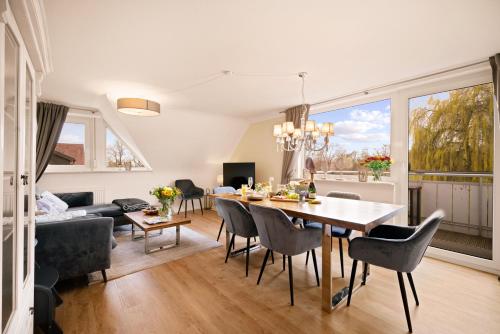 una sala da pranzo e un soggiorno con tavolo e sedie. di Ferien-Apartment Eisvogel im Naturschutzgebiet mit Privatstrand a Friedrichshafen