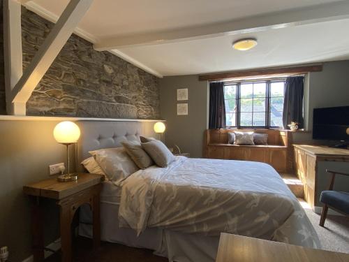 a bedroom with a bed and a stone wall at Tom's of Tregaron in Tregaron