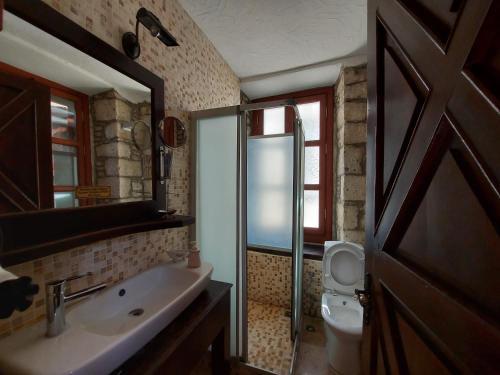 a bathroom with a sink and a toilet and a mirror at 1882 Hotel in Alaçatı
