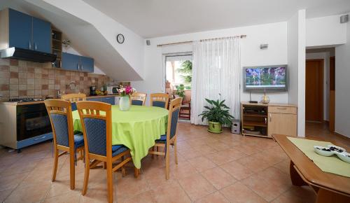 a kitchen and dining room with a table and chairs at Apartmani NEDOKLAN in Srima