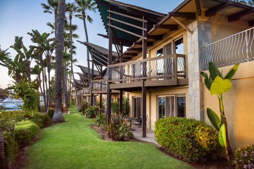 a building with a balcony and a grass yard at Humphreys Half Moon Inn in San Diego