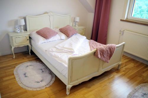 a bedroom with a white bed and two night stands at zaKRZYWEk wyjątkowy apartament w Krzywe k/Cisnej in Cisna