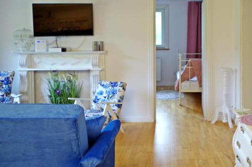 a living room with a blue couch and a fireplace at zaKRZYWEk wyjątkowy apartament w Krzywe k/Cisnej in Cisna