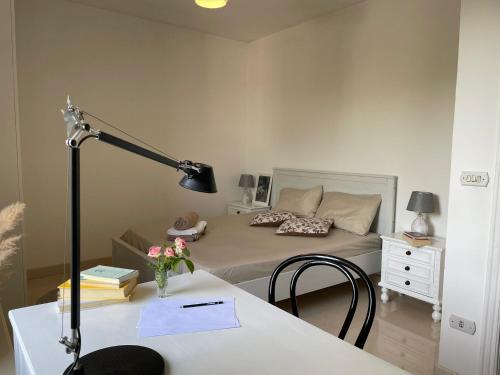 a bedroom with a bed and a desk with a lamp at MASSERIA INCANTAMENTO Suite Bouganville in Latiano