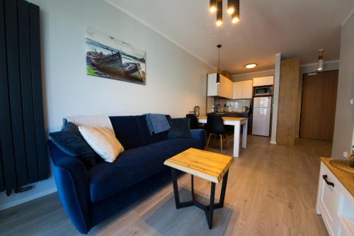 a living room with a blue couch and a table at Wyspa Uznam Sun Tower in Świnoujście