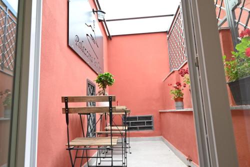un balcone con 2 sedie e una parete rossa di B&B Palazzina Avallone a Napoli
