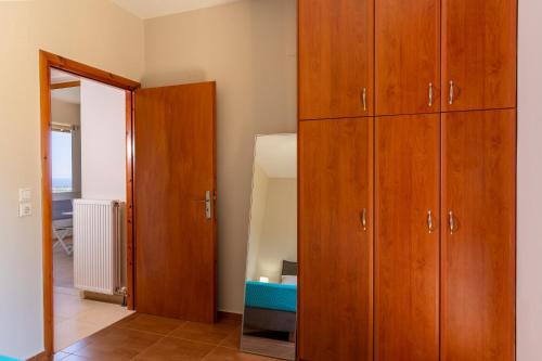 a room with wooden cabinets and a mirror at Linari Villa, a peaceful & cozy 2bdr villa with private pool! in Agia Triada