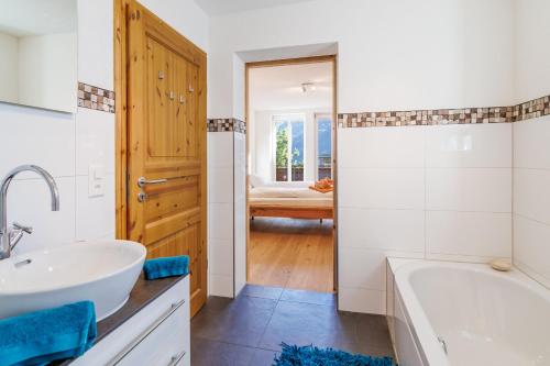 une salle de bain avec une baignoire et un lavabo dans l'établissement Le Manoir 5, à Wengen
