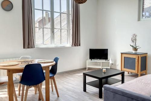 a living room with a table and a couch at AMX3 - L'horizon des vues de l'espace et du bien être in Ault