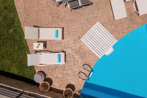 an overhead view of a pool with a table and chairs at Linari Villa, a peaceful & cozy 2bdr villa with private pool! in Agia Triada