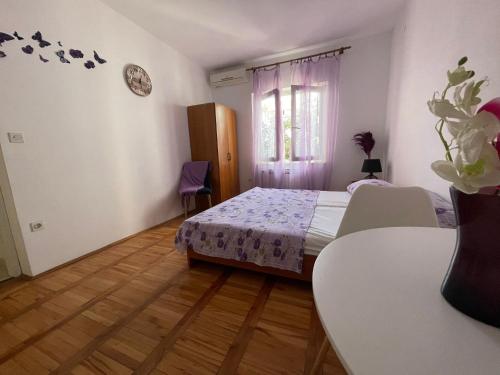 a bedroom with a bed and a table and a window at apartmani Mirko Storić in Vodice