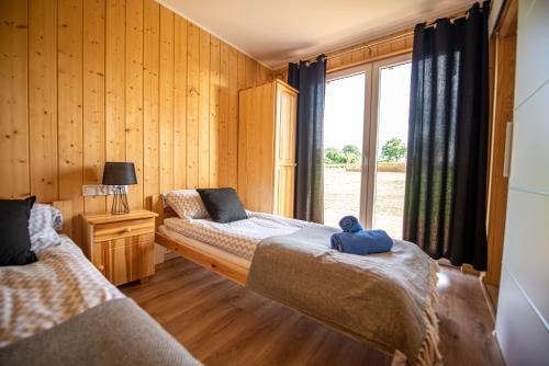 - 2 lits dans une chambre avec fenêtre dans l'établissement Siedlisko 14 Chata, à Mikołajki