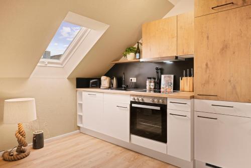a kitchen with white cabinets and a window at Ferien-Apartment Seewiesen - mit priv Strandzugang in Friedrichshafen