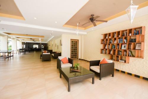 a living room with couches and chairs and a book shelf at Microtel by Wyndham Boracay in Boracay