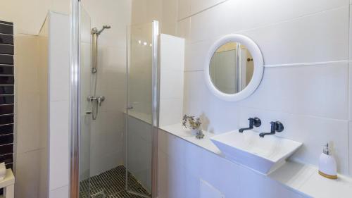 La salle de bains blanche est pourvue d'un lavabo et d'une douche. dans l'établissement Villa Javier Torrox by Ruralidays, à Torrox