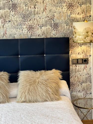 a bedroom with a bed with a blue headboard at Oviedo Real Spa in Oviedo