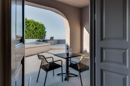 a patio with a table and chairs on a balcony at Elements Cozy Suites Pyrgos in Pirgos
