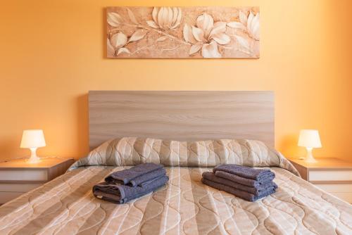 a bedroom with a bed with two towels on it at Casa Vacanza Brucoli Mare 2 in Brucoli
