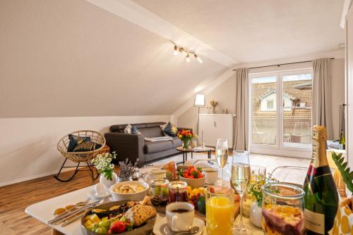 ein Wohnzimmer mit einem Tisch mit Speisen und Getränken in der Unterkunft Ferien-Apartment Riedperle mit Privatstrandzugang in Friedrichshafen