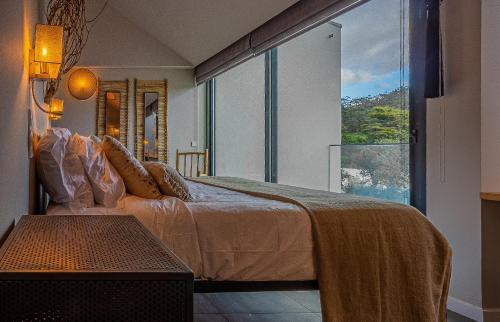 a bedroom with a large bed and a large window at Villa Cerrado das Fontainhas SPA in Sintra