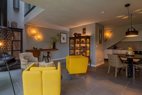 a living room with yellow chairs and a table at Villa Cerrado das Fontainhas SPA in Sintra