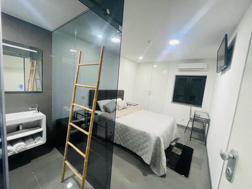 a bedroom with a ladder and a bed and a sink at Ergosuites in Figueira da Foz