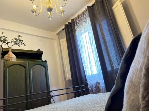 a bedroom with a bed and a window with a chandelier at Tenuta delle Acque in Acquasparta