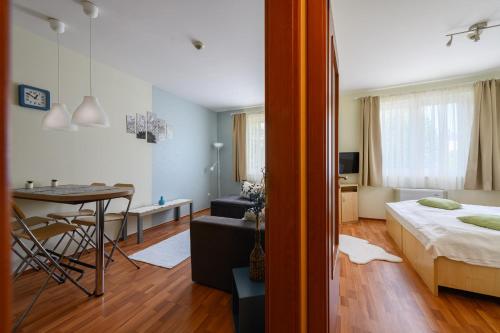 a bedroom with a bed and a table and a dining room at Mirage Wellness Apartman in Hajdúszoboszló