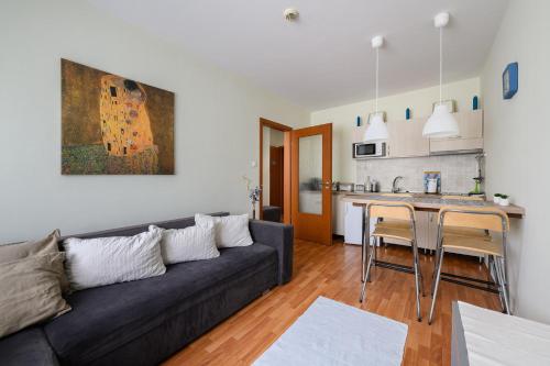 uma sala de estar com um sofá e uma cozinha em Mirage Wellness Apartman em Hajdúszoboszló