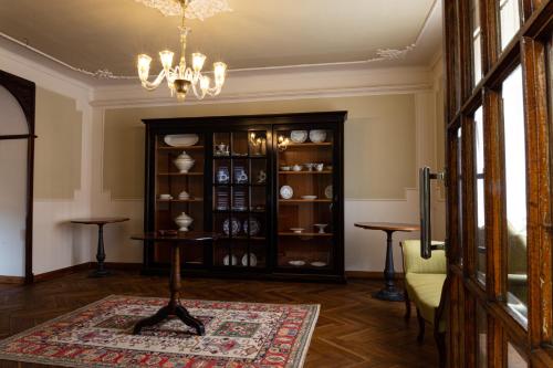 a living room with a chandelier and a room with a table at Maison Flipot in Torre Pellice