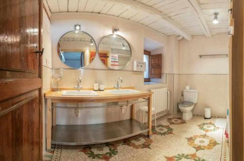 a bathroom with two sinks and a toilet at Casa Rural La Chascona in Pedrajas
