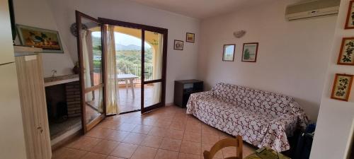a living room with a couch and a sliding glass door at casa di Chiara in San Teodoro