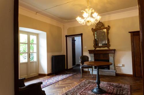 a living room with a table and a chandelier at Maison Flipot in Torre Pellice
