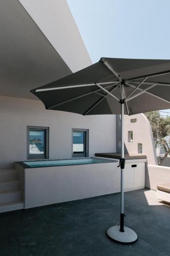 a large umbrella in a room with a swimming pool at Elements Cozy Suites Pyrgos in Pirgos