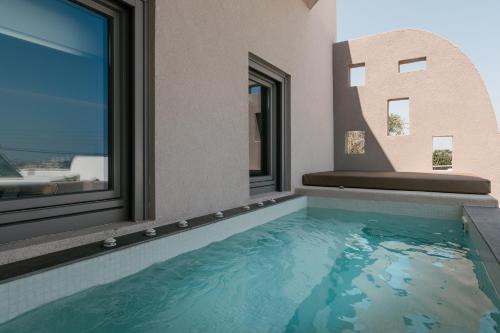 a swimming pool in a house with a window at Elements Cozy Suites Pyrgos in Pirgos
