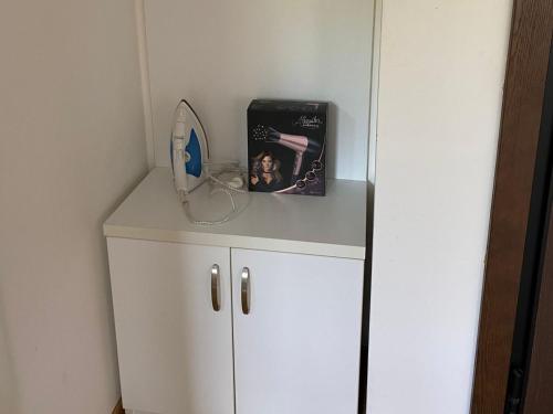 a small white cabinet with a mirror on top of it at Apartmani CENTAR Vrnjacka Banja & Free Parking in Vrnjačka Banja