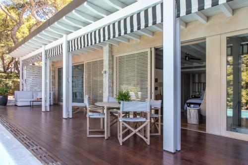 a patio with a table and chairs on a deck at Four Seasons Astir Palace Hotel Athens in Athens
