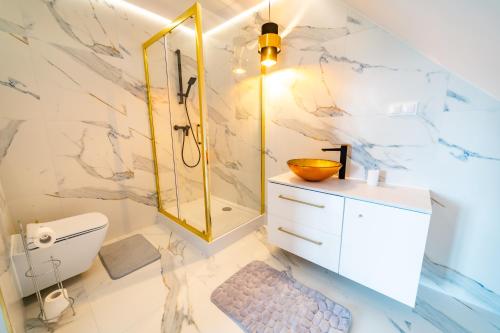 La salle de bains est pourvue d'une douche, de toilettes et d'un lavabo. dans l'établissement Apartamenty Mazurskie, à Mikołajki