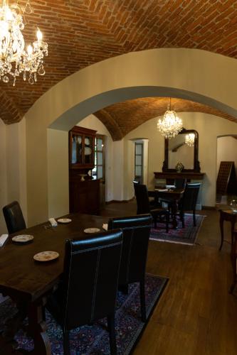 a dining room with a table and chairs and a chandelier at Maison Flipot in Torre Pellice