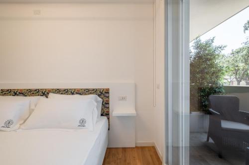 a bedroom with a bed and a desk and a window at Helios Guest House in Cagliari