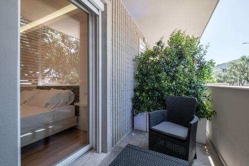a balcony with a chair and a bed and a window at Helios Guest House in Cagliari