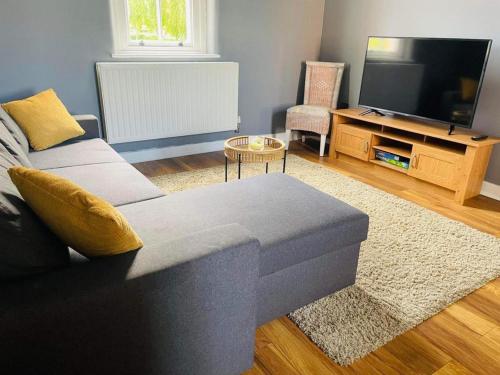 a living room with a couch and a television at 2 Bed Self Contained Apartment Wrexham in Wrexham