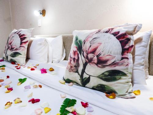 a bed with two pillows and flowers on it at Lions Rock Rapids - Lodge in Hazyview