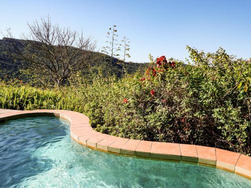 a swimming pool with a path in the water at Lions Rock Rapids - Lodge in Hazyview