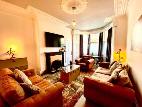 a living room with two couches and a fireplace at Anchored Homely Apartment in Historic Centre in Paisley